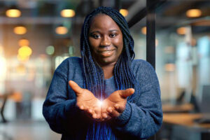 African american plus size woman with braids wearing casual sweater over blue background Smiling with hands palms together receiving or giving gesture. Hold and protection